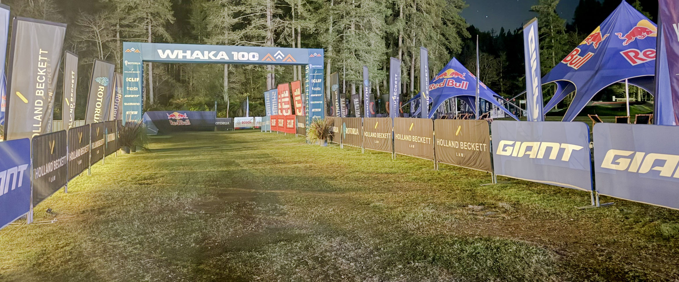 Illuminated outdoor event finish area with branded structures and lighting